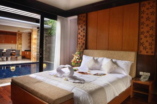a bedroom with two swans sitting on a bed at Kori Maharani Villas & Resort in Keramas