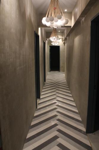 a hallway with a long corridor with a chandelier at Citizen Hotel in Manila