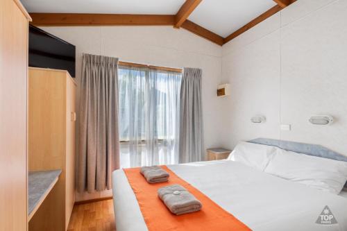 1 dormitorio con 1 cama con 2 toallas en Broken Hill Tourist Park, en Broken Hill