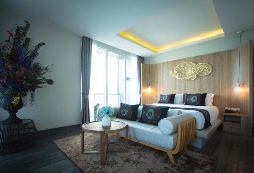 a bedroom with a bed and a couch and a table at Maldives Beach Resort in Chao Lao Beach