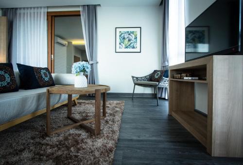 a living room with a couch and a table at Maldives Beach Resort in Chao Lao Beach