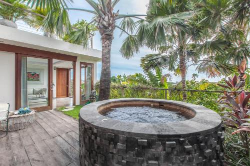 una bañera de hidromasaje en un patio con palmeras en AB Villa & Apartments, en Seminyak
