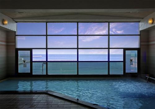 a large room with a pool with a view of the ocean at Kaigetsukan in Sumoto