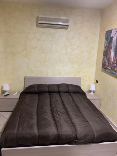 a bedroom with a bed and a lamp on the wall at Airport Bedroom House in Catania