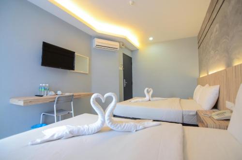 two swans sitting on beds in a hotel room at Suite Dreamz Hotel in Kuala Lumpur