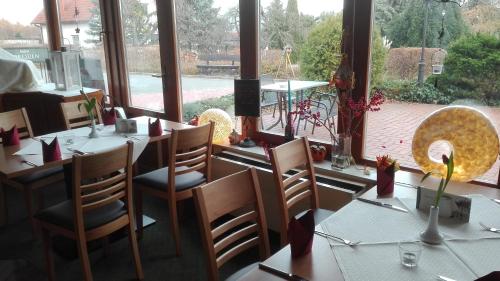 a restaurant with tables and chairs and a large window at Landhotel Dresden in Dresden