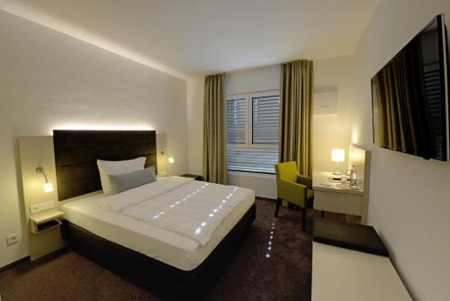 インゴルシュタットにあるHotel am Campusのベッドとデスクが備わるホテルルームです。