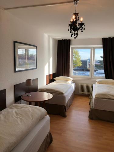 a hotel room with two beds and a chandelier at Big Space-Loft in Hannover