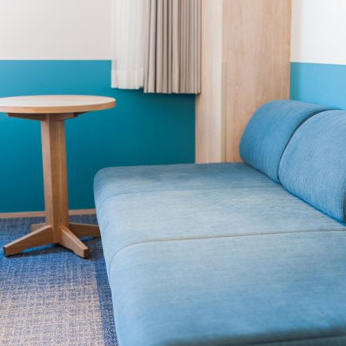a bed and a table in a room at Art Hotel Asahikawa in Asahikawa