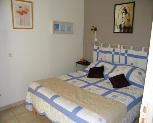 - une chambre dotée d'un lit bleu et blanc avec deux oreillers dans l'établissement Domaine du bois gîte Bleuette, à Galargues