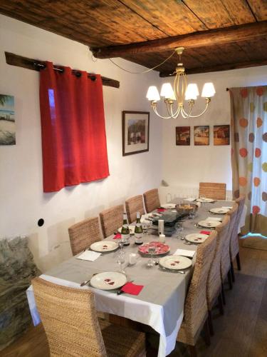 a long dining room table with chairs and a chandelier at Ferme Saint-Aubin in Sainte-Foy-Tarentaise