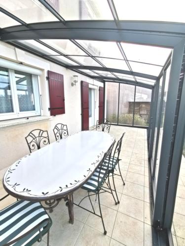 d'une terrasse avec une table blanche et des chaises. dans l'établissement Au Clos des Bulles Champenoises, à Morangis