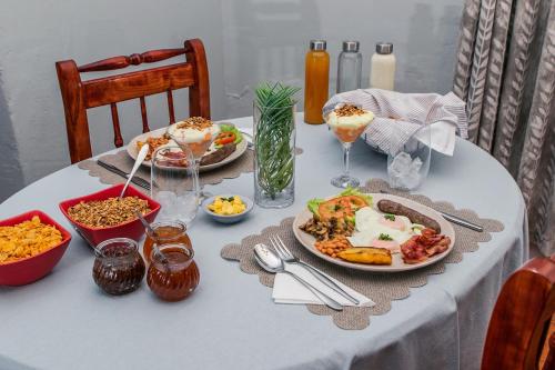 a table with plates of food and drinks on it at @karoo Guesthouse in Graaff-Reinet