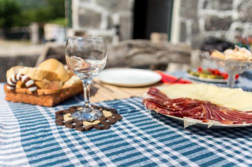 a table with a wine glass and a plate of food at Ethno House Kosic in Herceg-Novi
