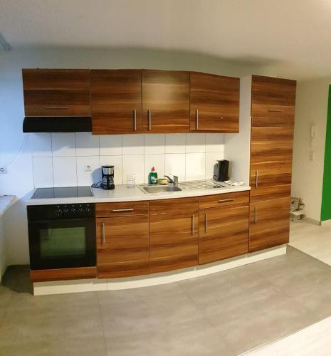 a kitchen with wooden cabinets and a sink at Monteurzimmer Ferienwohnungen Fritsche-Bad Mergentheim in Bad Mergentheim