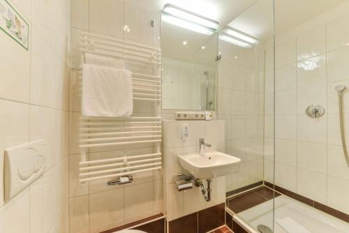 a white bathroom with a sink and a shower at Gasthaus Pillhofer in Nuremberg