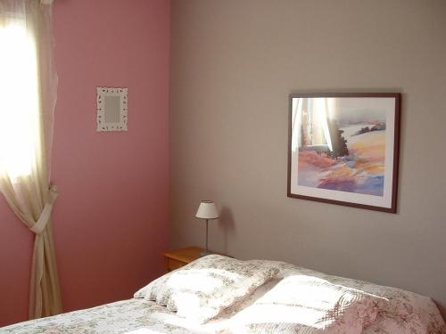 - une chambre avec un lit et une photo sur le mur dans l'établissement Acaba d'Entrar, à Le Caylar