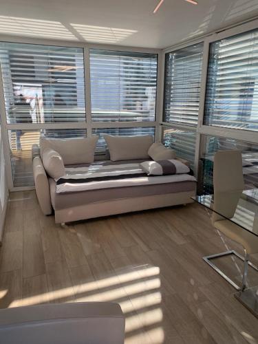 a living room with a couch and some windows at Apartments in Villa Olimp in Ljubljana