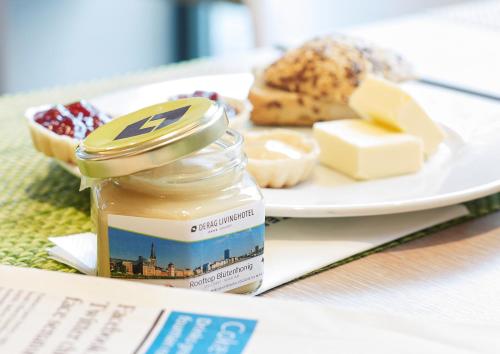 Un plato de comida con un tarro de miel y queso. en Living Hotel Düsseldorf, en Düsseldorf