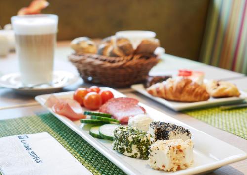 una mesa con dos platos de comida y un vaso de leche en Living Hotel Düsseldorf, en Düsseldorf