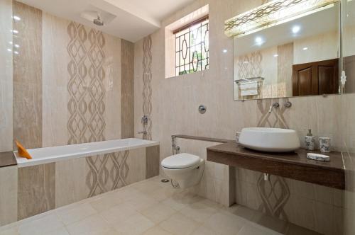 a bathroom with a sink and a toilet and a tub at Villa Calangute Phase 2 in Calangute