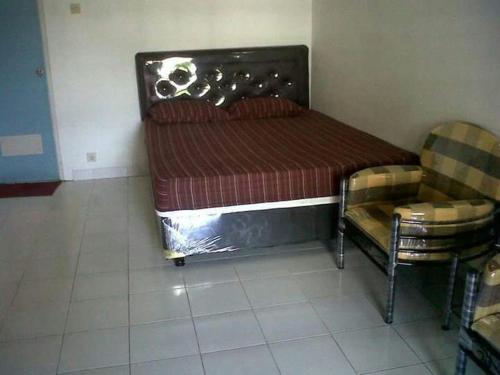 łóżko i krzesło w pokoju w obiekcie Griya Palayu w mieście Bogor