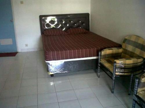 - un lit et une chaise dans une chambre dans l'établissement Griya Palayu, à Bogor