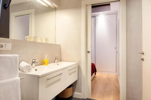 バルセロナにあるAkira Flats Urgell apartmentの白いバスルーム(シンク、鏡付)
