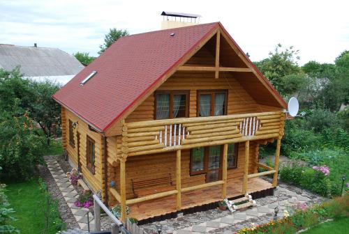 a log cabin with a red roof at Смерекова хата in Pochayiv