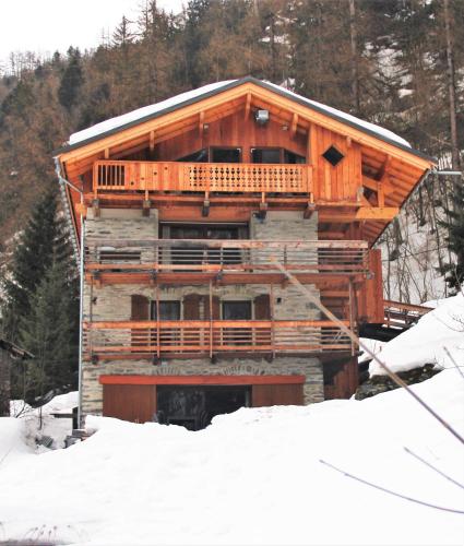 a large log cabin in the snow with trees at Ferme Saint-Aubin in Sainte-Foy-Tarentaise