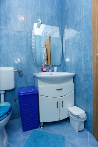 a bathroom with a sink and a toilet and a mirror at Margareta's Apartment in Kaštela