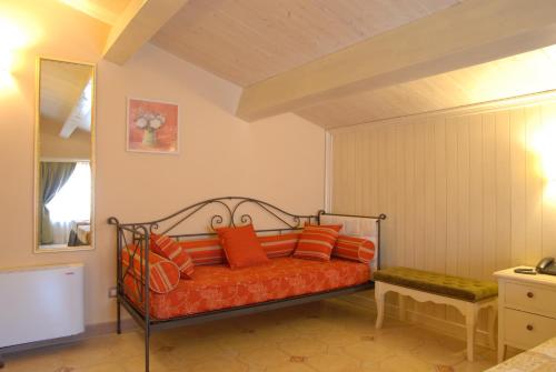 an orange bed with orange pillows in a room at Tenuta Del Perugino in Bettona