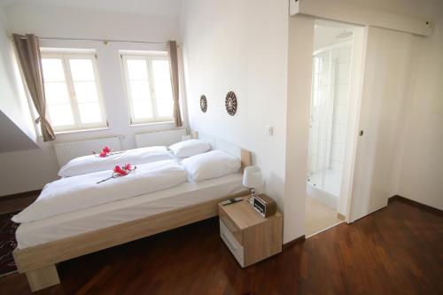 a bedroom with a large white bed with flowers on it at Hotel Vila Katrca in Ljubljana