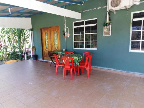 een eetkamer met rode stoelen en een tafel bij Adeeva Homestay Langkawi in Pantai Cenang