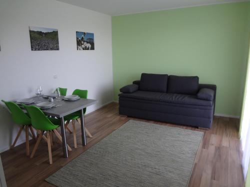 uma sala de estar com um sofá, uma mesa e cadeiras em Weinstraßenapartment Fam. Dietrich em Ratsch an der Weinstraße