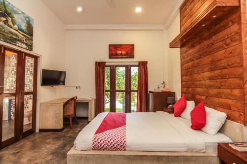 1 dormitorio con 1 cama grande con almohadas rojas en Gomez Place, en Negombo