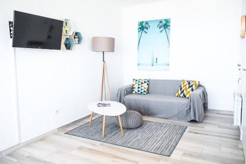 sala de estar con sofá y mesa en "PLAGE" Splendide Vue Mer depuis la chambre et le salon cuisine, 20m de la plage!, en Canet-en-Roussillon