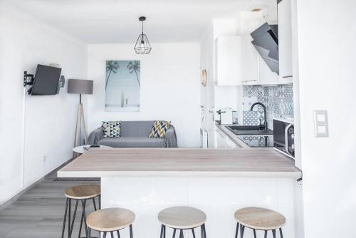 cocina y sala de estar con encimera y taburetes en "PLAGE" Splendide Vue Mer depuis la chambre et le salon cuisine, 20m de la plage!, en Canet-en-Roussillon