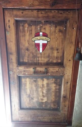 a wooden door with a crest on it at Ferme Saint-Aubin in Sainte-Foy-Tarentaise