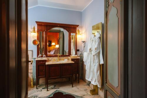 a bathroom with a sink and a large mirror at Relais & Chateaux Villa Crespi in Orta San Giulio