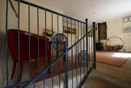 un escalier avec une balustrade bleue dans une pièce dans l'établissement La Moinerie Village, à Sark