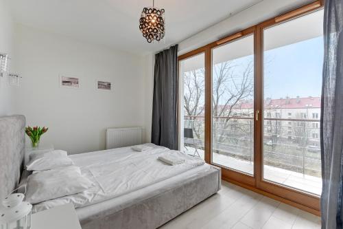 1 dormitorio con cama y ventana grande en Apartamenty Apartinfo Gwiazda Morza, en Władysławowo