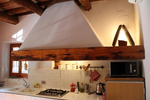 a kitchen with a hood over a stove and a sink at Podere Fichereto Tuscany Apartment in Florence countryside in Scandicci