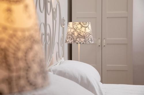 a bedroom with a bed with a lamp and a mirror at Hirscher Apartments in Braşov