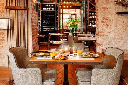 a table with plates of food on it in a restaurant at Balthazar Design Hotel in Kraków