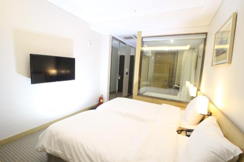 a hotel room with a bed and a window at Hotel Migliore Seoul in Seoul