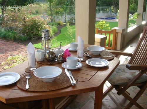 einem Holztisch mit Tellern und Utensilien darauf in der Unterkunft Woodcutter's Bush Camp at The Old Trading Post in Wilderness