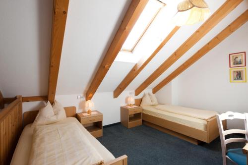 a bedroom with two beds in a attic at Hotel Amaten in Brunico