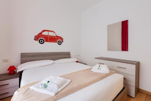 - une chambre avec un lit avec une voiture rouge sur le mur dans l'établissement Buenos Aires & Lima Cosy Flat, à Milan