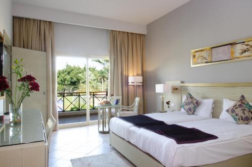 a hotel room with a bed and a balcony at Swiss Inn Pyramids Golf Resort in 6th Of October
